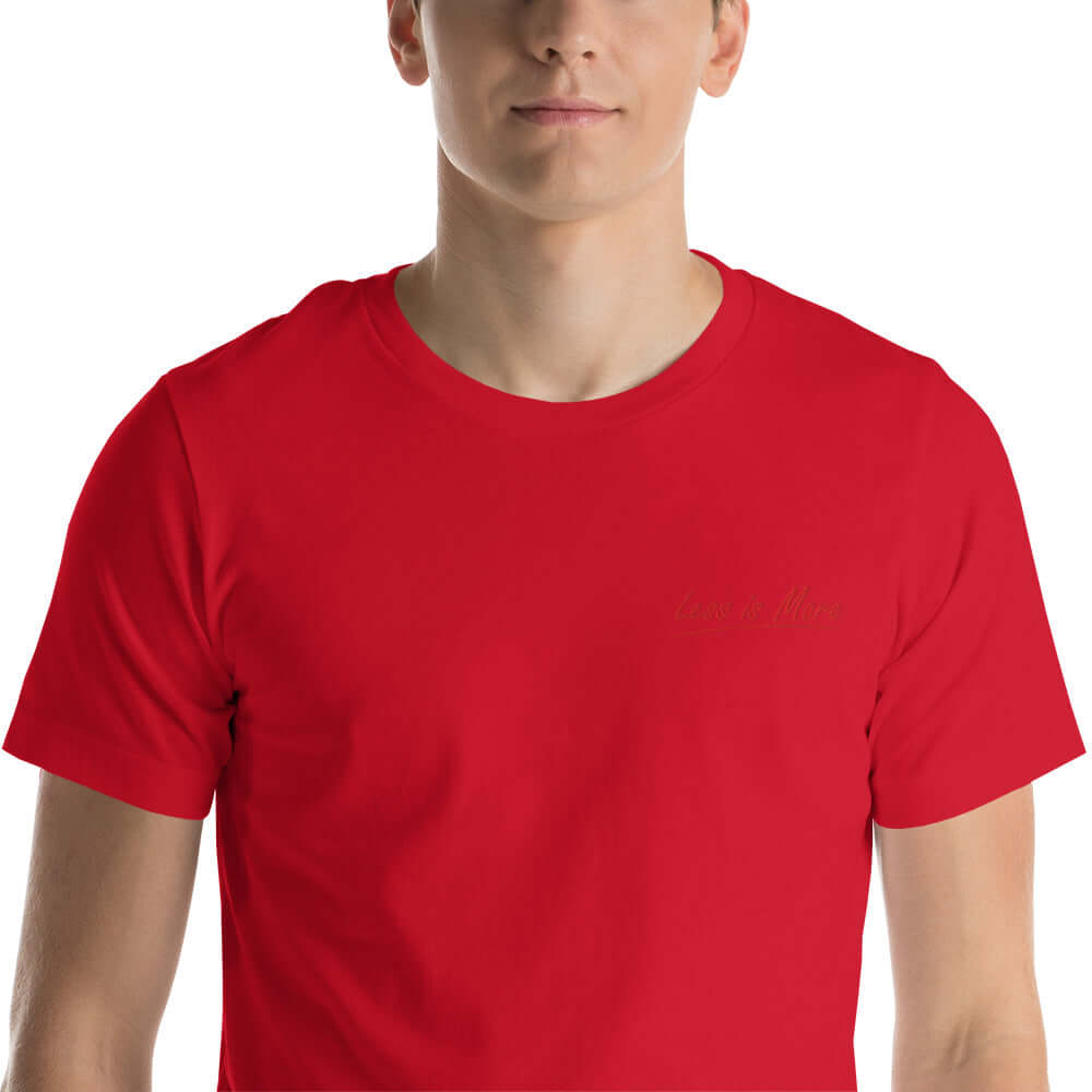 Close-up of the red 'Less is More' embroidery on the black t-shirt.