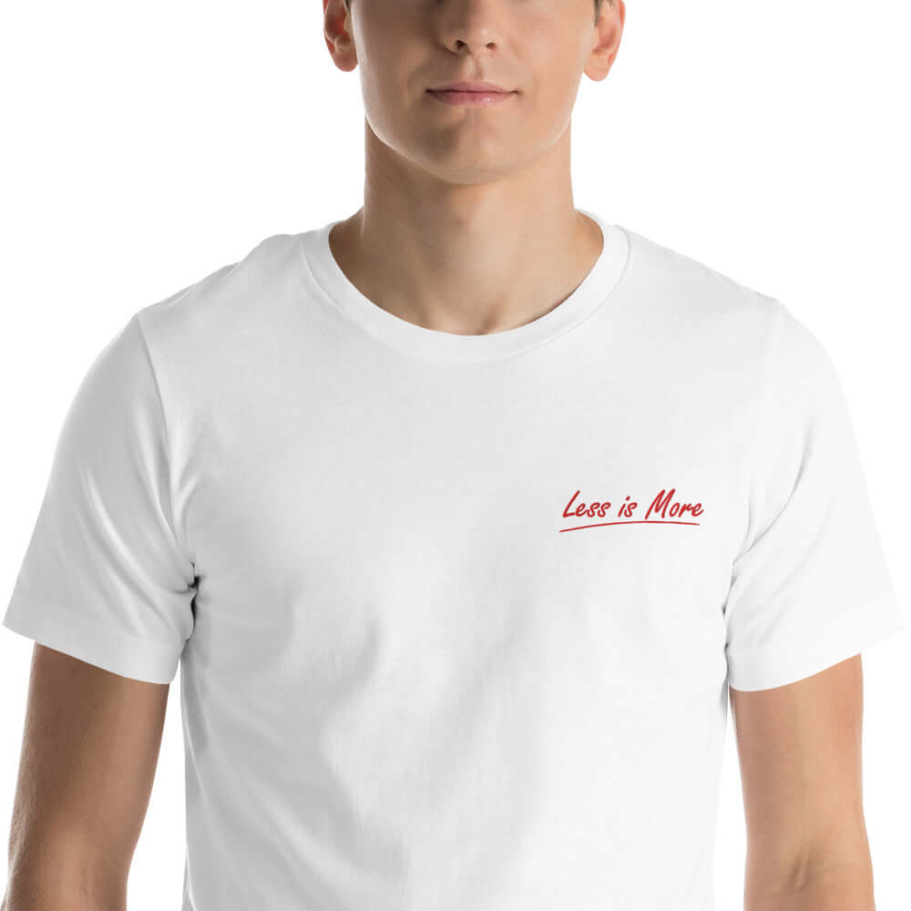 Close-up of the red 'Less is More' embroidery on the white t-shirt.